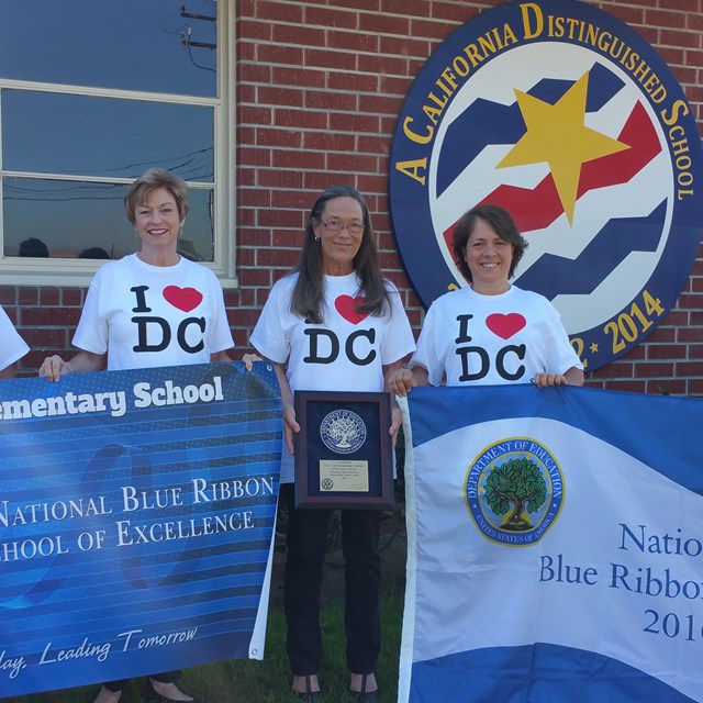 Staff and volunteers celebrate Blue Ribbon pride with their t-shirts and signs.