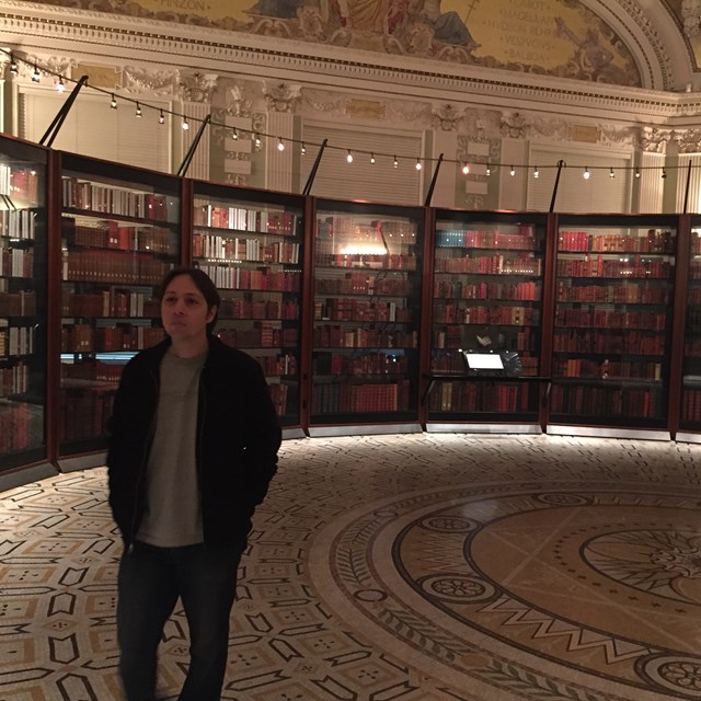 Look at this student standing in a vast library!