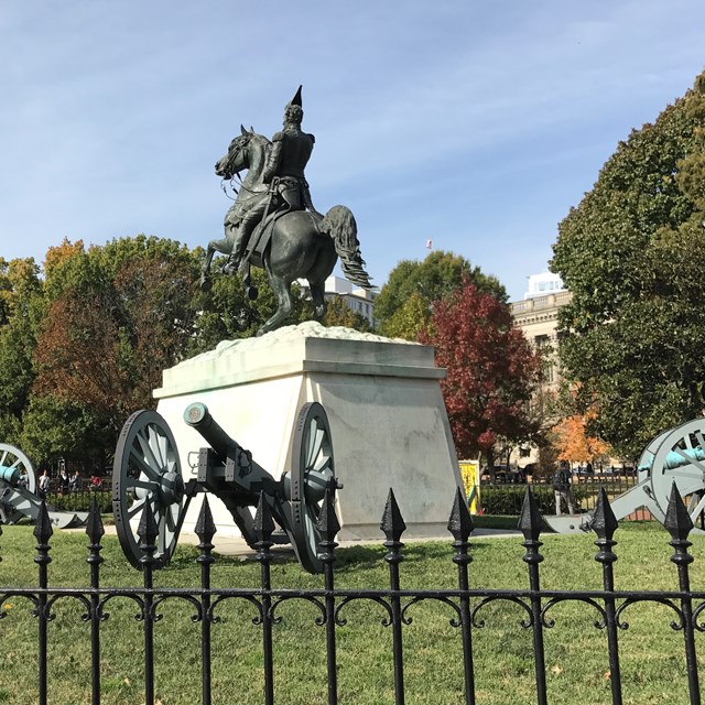 A statue of Paul Revere in the middle of a park.